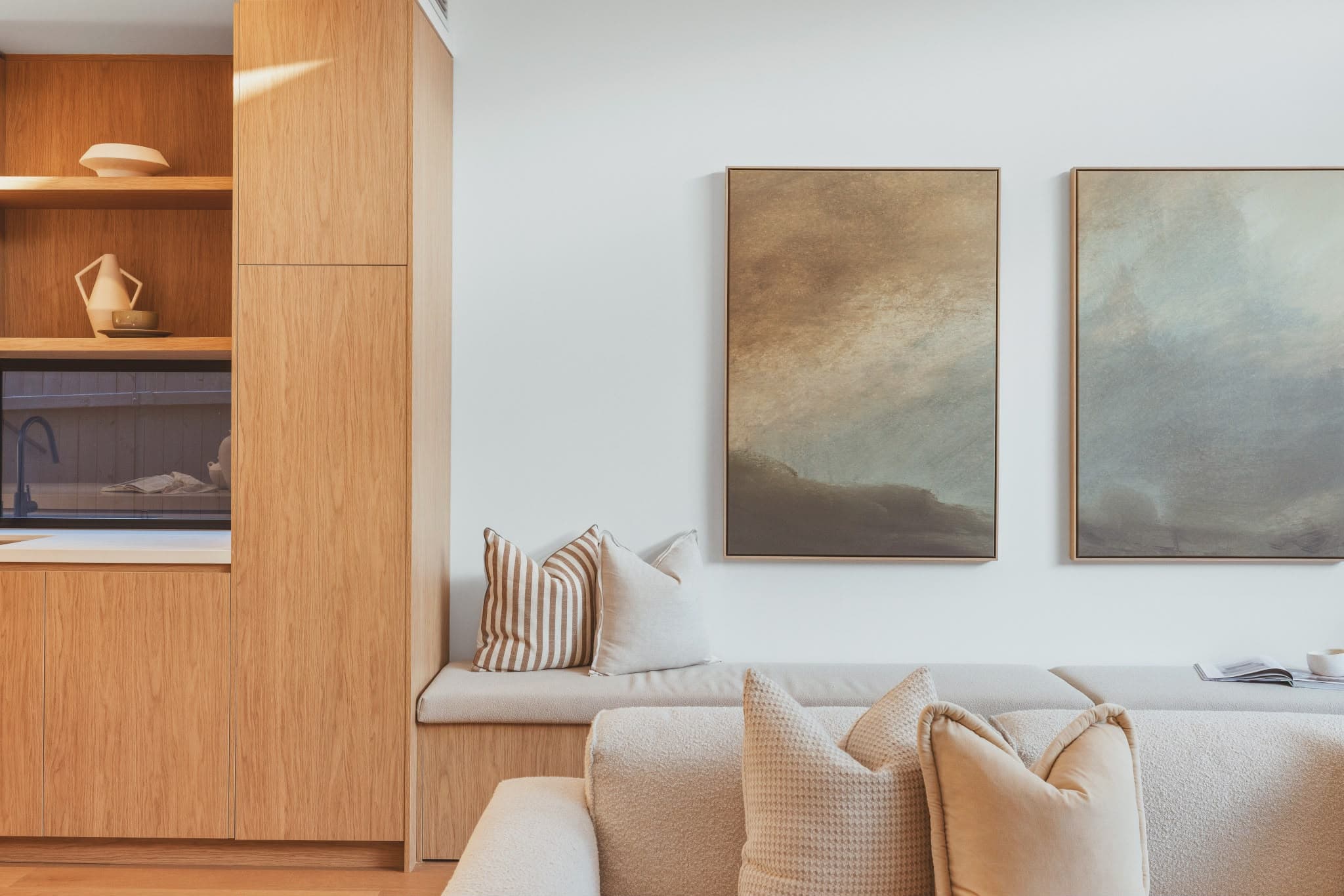 Built-in timber shelving styled with framed artwork and cushions, a finished Sequoia project