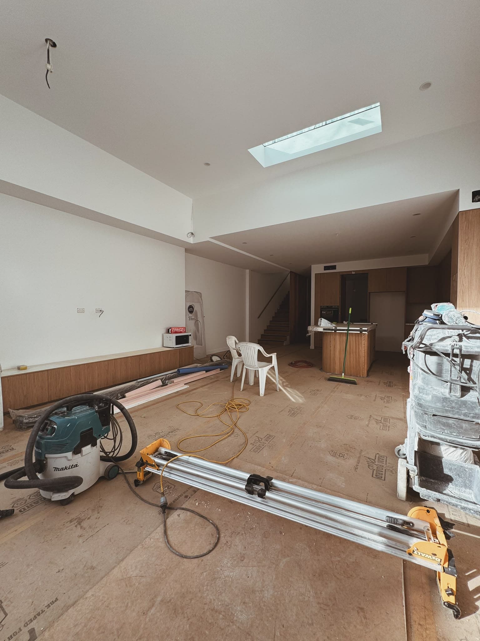 Residential construction site mid-build with framing, subfloor and tools in progress