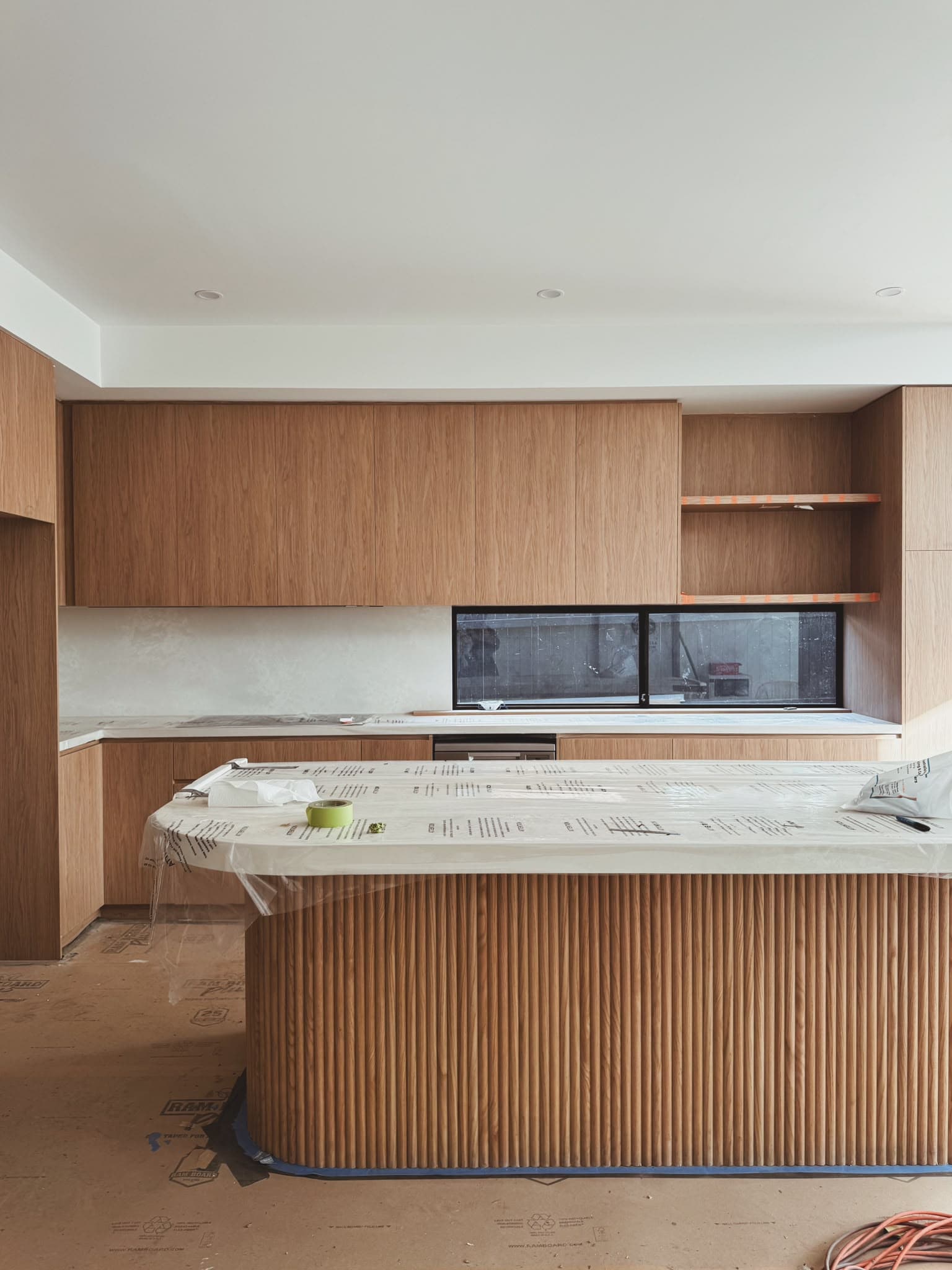 Kitchen under construction with timber veneer cabinetry and joinery being installed