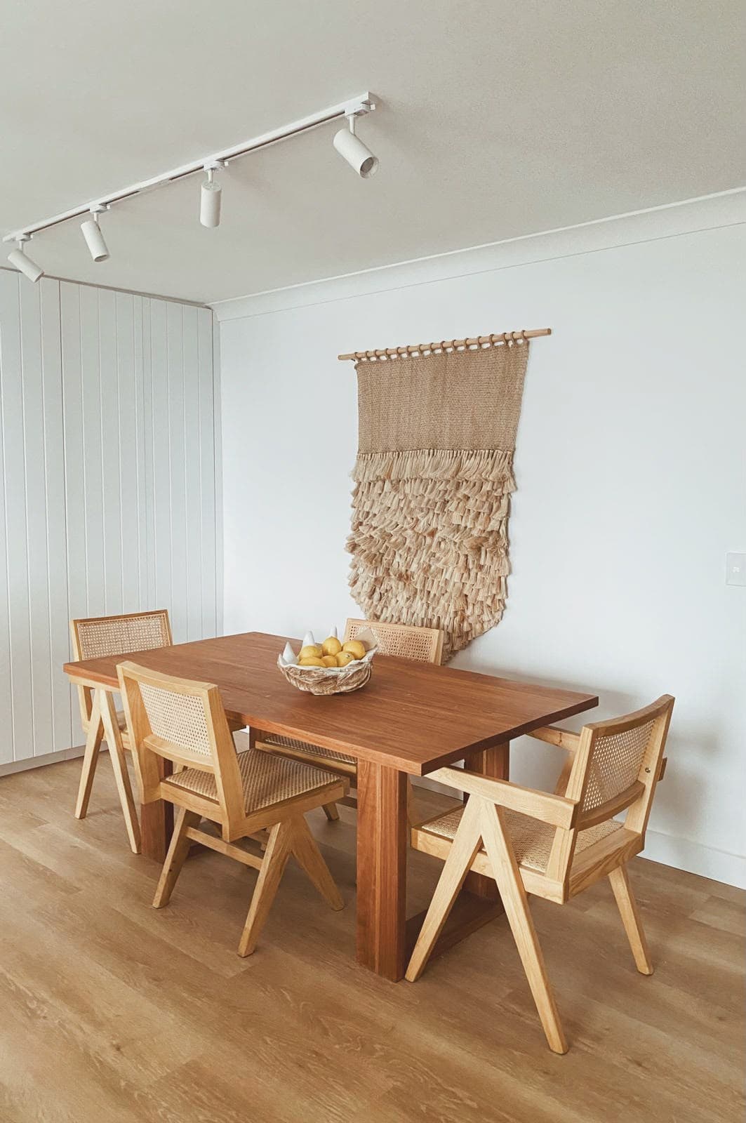 Dining table with cane armchairs and woven wall hanging, Penkivil St Bondi