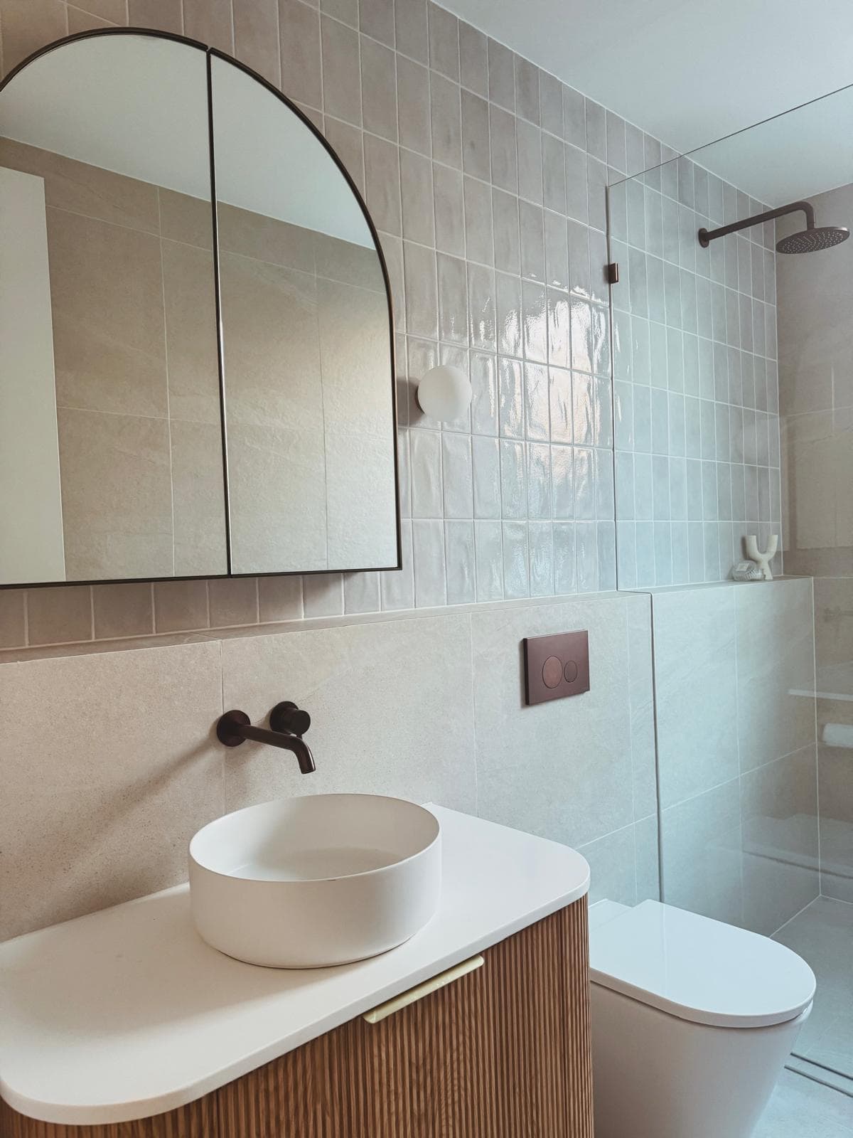 Bathroom with arched mirrored cabinet, freestanding vanity and black tapware, 64 Botany St